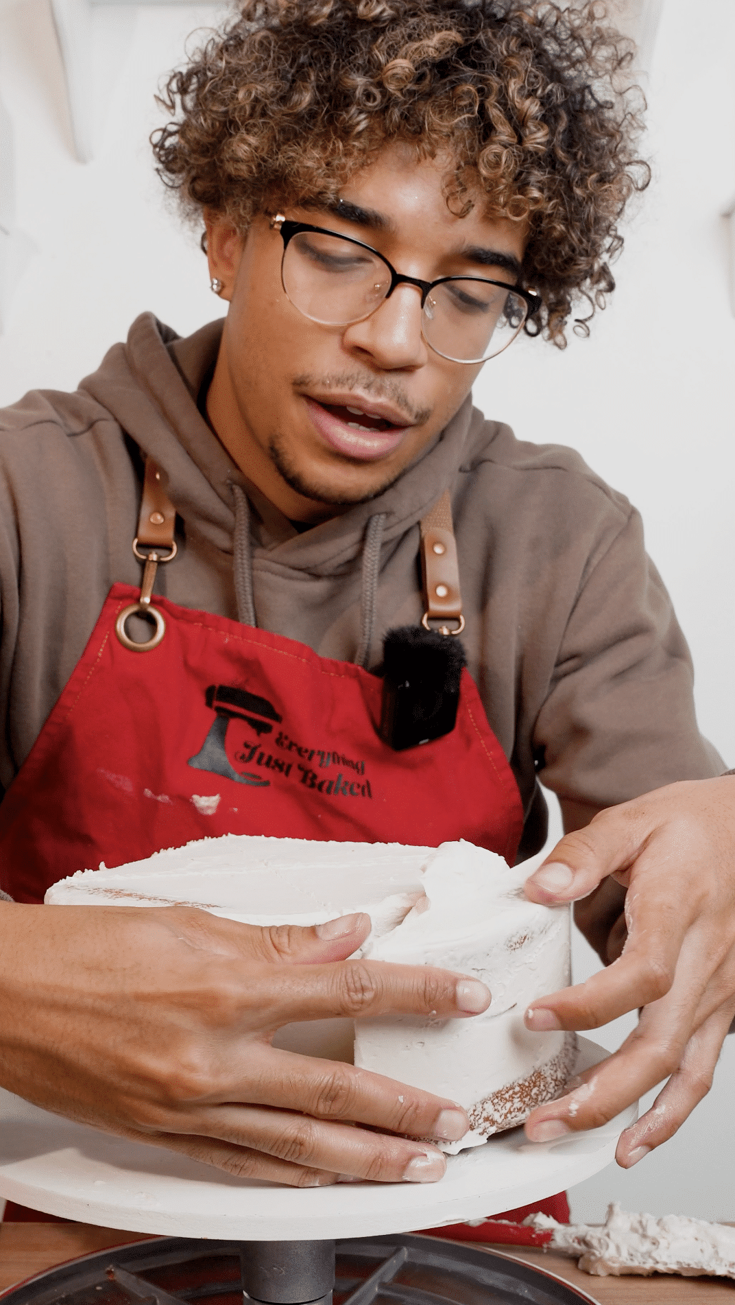 Baker attaching cut cake sections to the top of a round cake to form the classic heart shape.